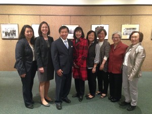 During her trip to Minnesota, Karen Korematsu (in plaid red coat) visited the MIS photographic exhibit at Historic Fort Snelling Visitors Center, accompanied by members of the Minnesota chapter of the National Asian Pacific American Bar Association (MN-NAPABA) and Twin Cities JACL Education Committee, May 20, 2015. Pictured L-R are: Keiko Sugisaka, Emily Faber- Densley, Magistrate Judge Tony Leung, Karen Korematsu (daughter of civil rights activist, Fred Korematsu), Karen Tanaka Lucas, Carolyn Nayematsu, Janet Carlson, and Sally Sudo.